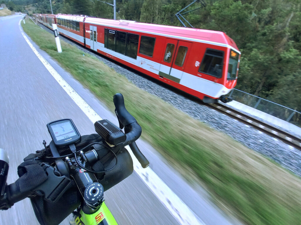 Cycling beside the red train to Zermatt in the Mattertal Valley, Switzerland