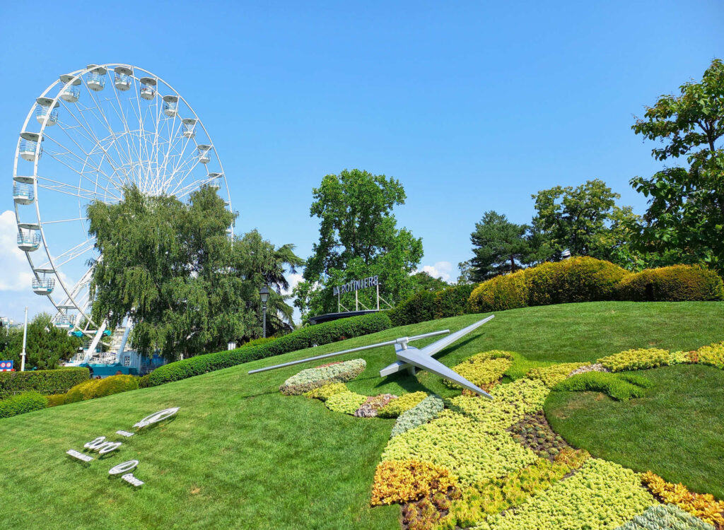 The famous flower clock in Jardin Anglais park in Geneva with the Ferris wheel in the background