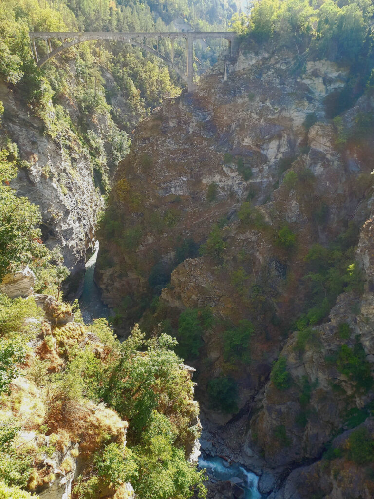Historic bridge spanning a deep gorge in the Mattertal Valley, Switzerland, with a river flowing far below
