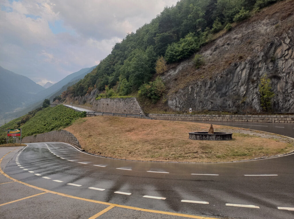Wet mountain road hairpin bend descending to Martigny in Valais, Switzerland
