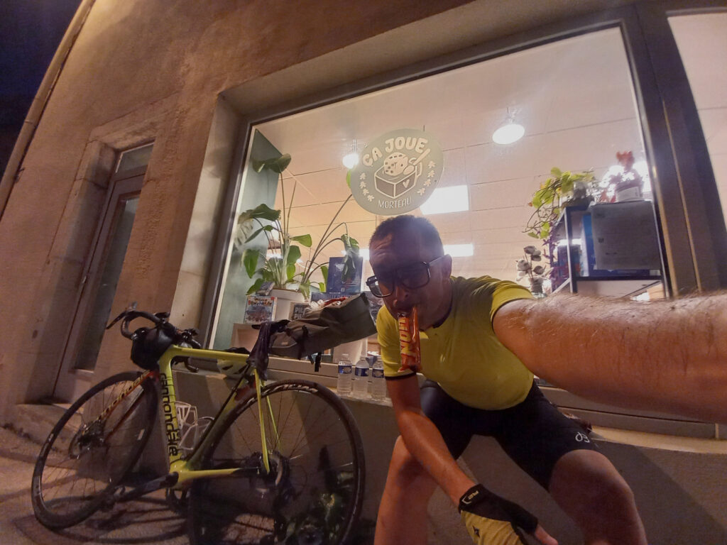 cyclist taking a food stop outside Ça Joue game café in Morteau, France