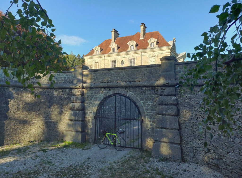 Bicycle parked in front of the stone gate of Château Maillot in France