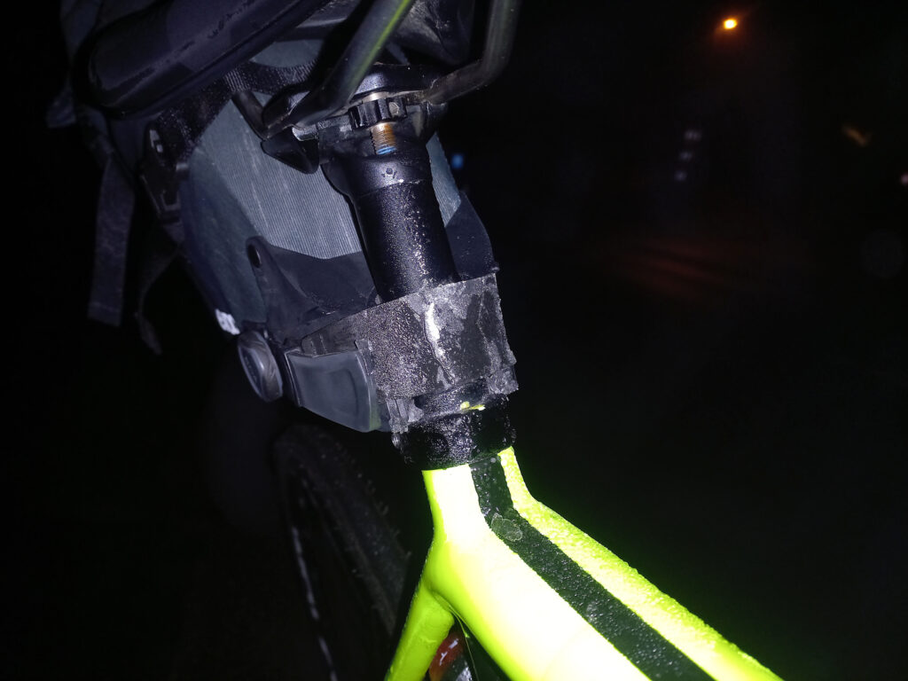 Frozen EVOC seat pack mount covered in moisture and ice during a cold foggy night cycling ride