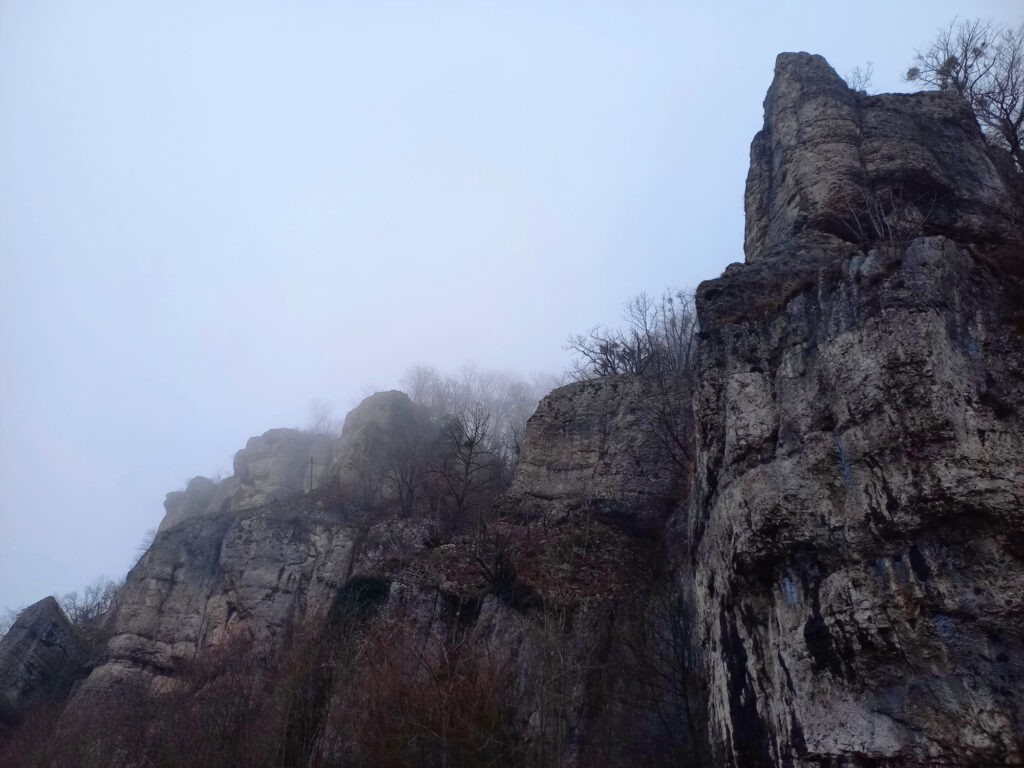 Misty rock cliffs in Thal Nature Park during a cold winter cycling ride in Switzerland