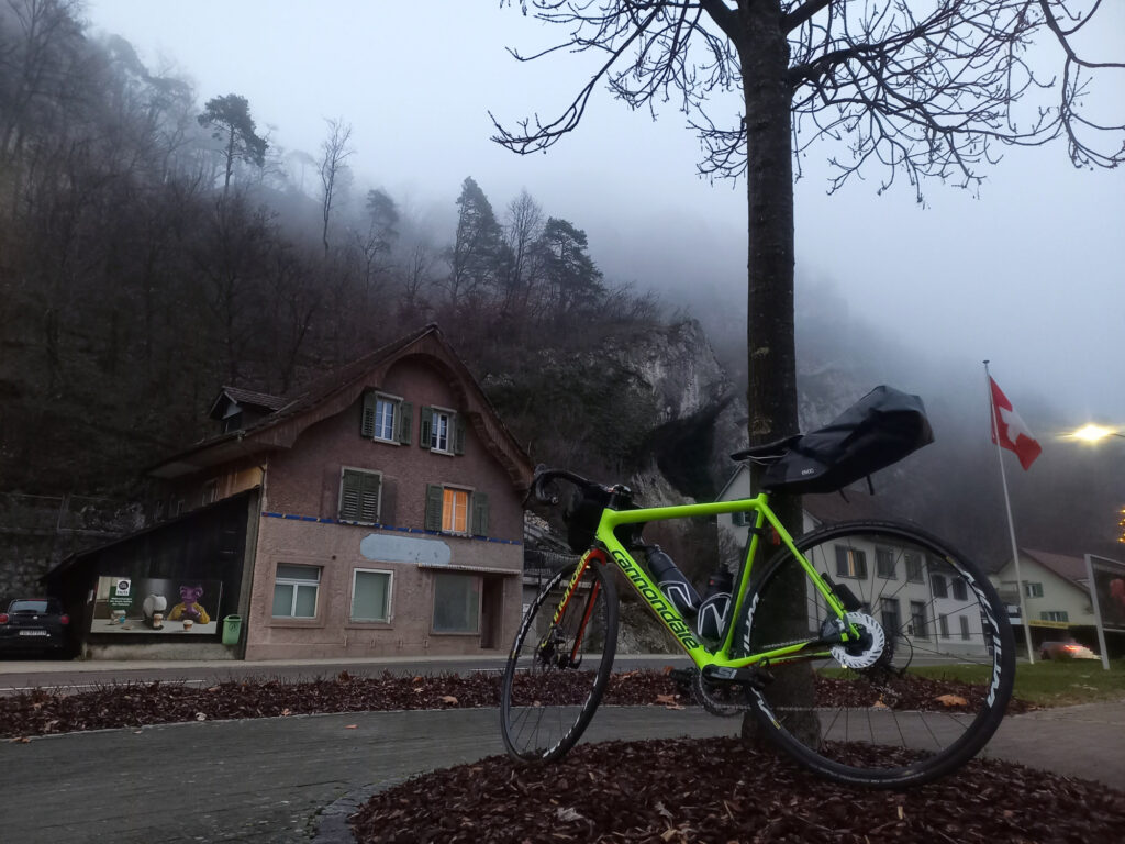 Road bike beneath mist-covered cliffs in Thal Nature Park during a cold winter ride in Switzerland