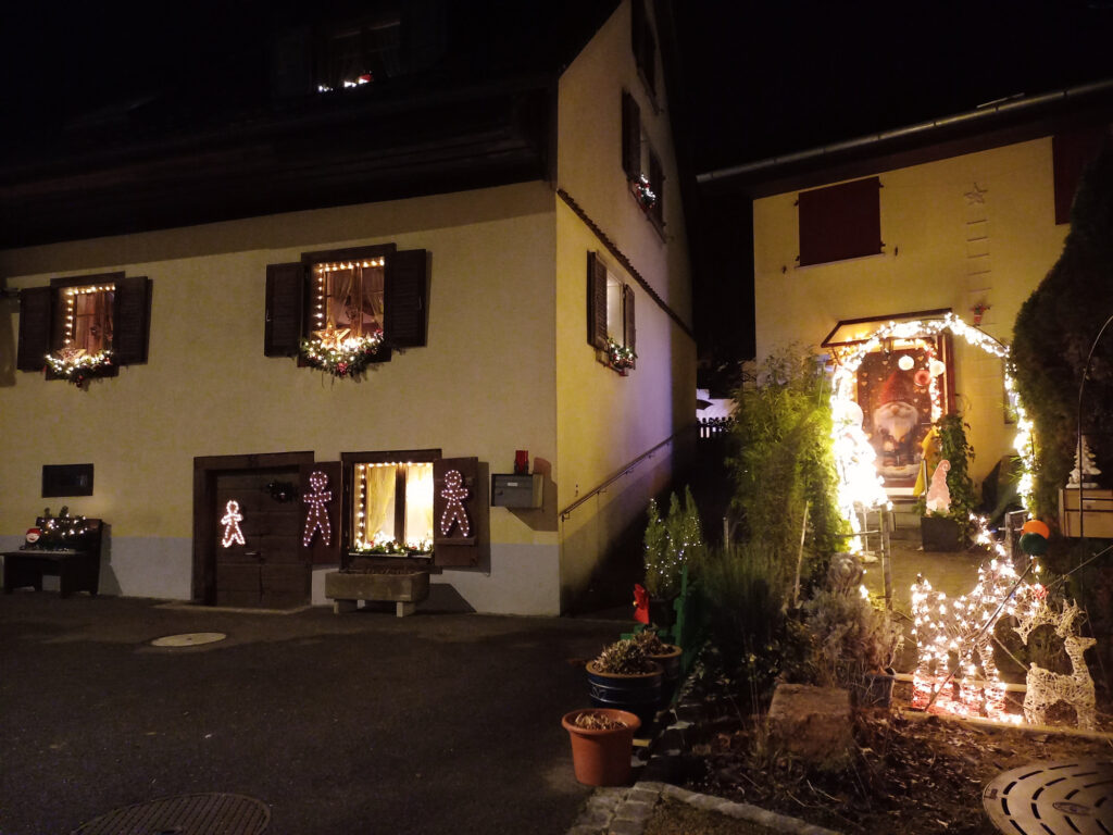 Traditional Christmas decorations on a quiet Swiss street during a cold night ride home