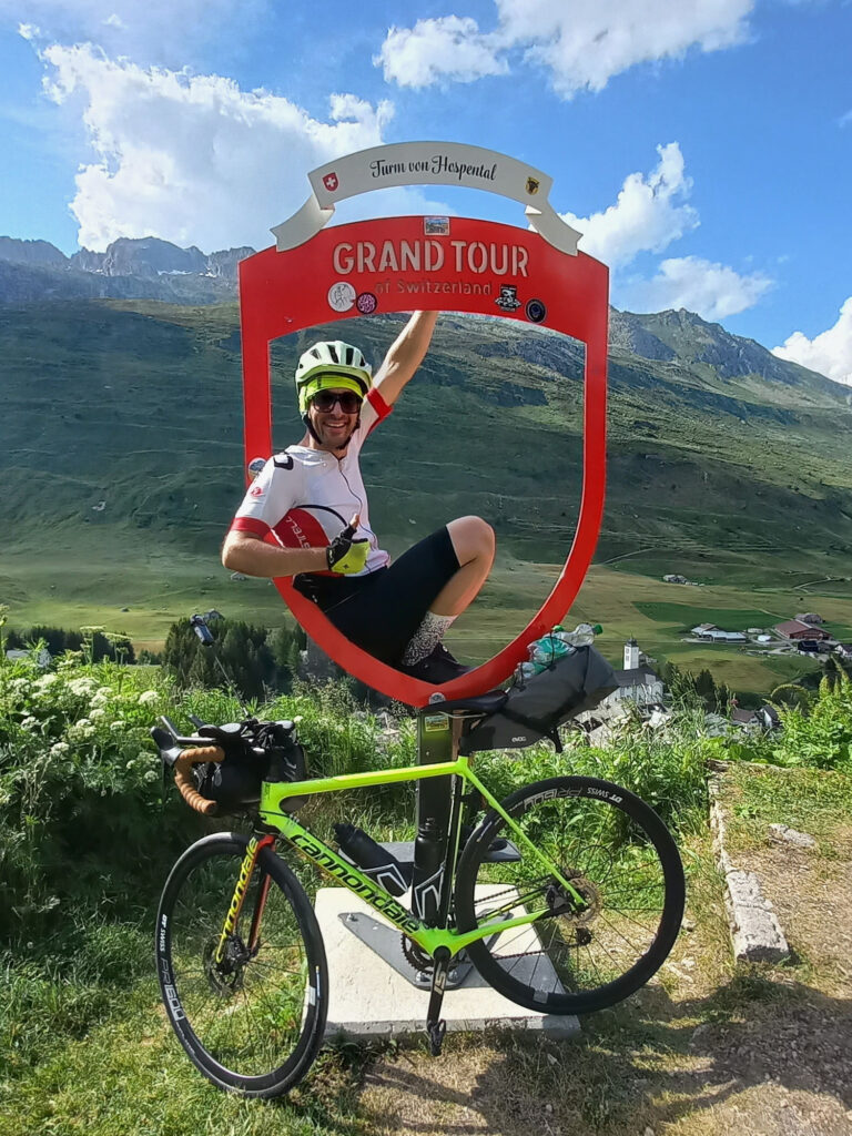 Cyclist posing in the Grand Tour of Switzerland frame in Hospental.