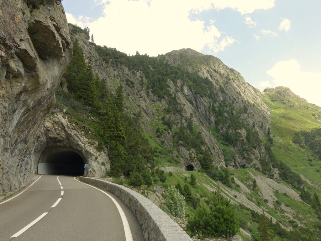 Mountain road entering a rock tunnel on Susten Pass.