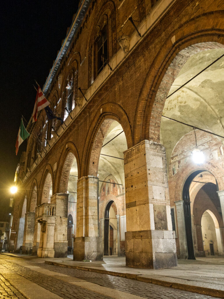 Nočný pohľad na tehlovú fasádu a arkády Palazzo Comunale v Cremone